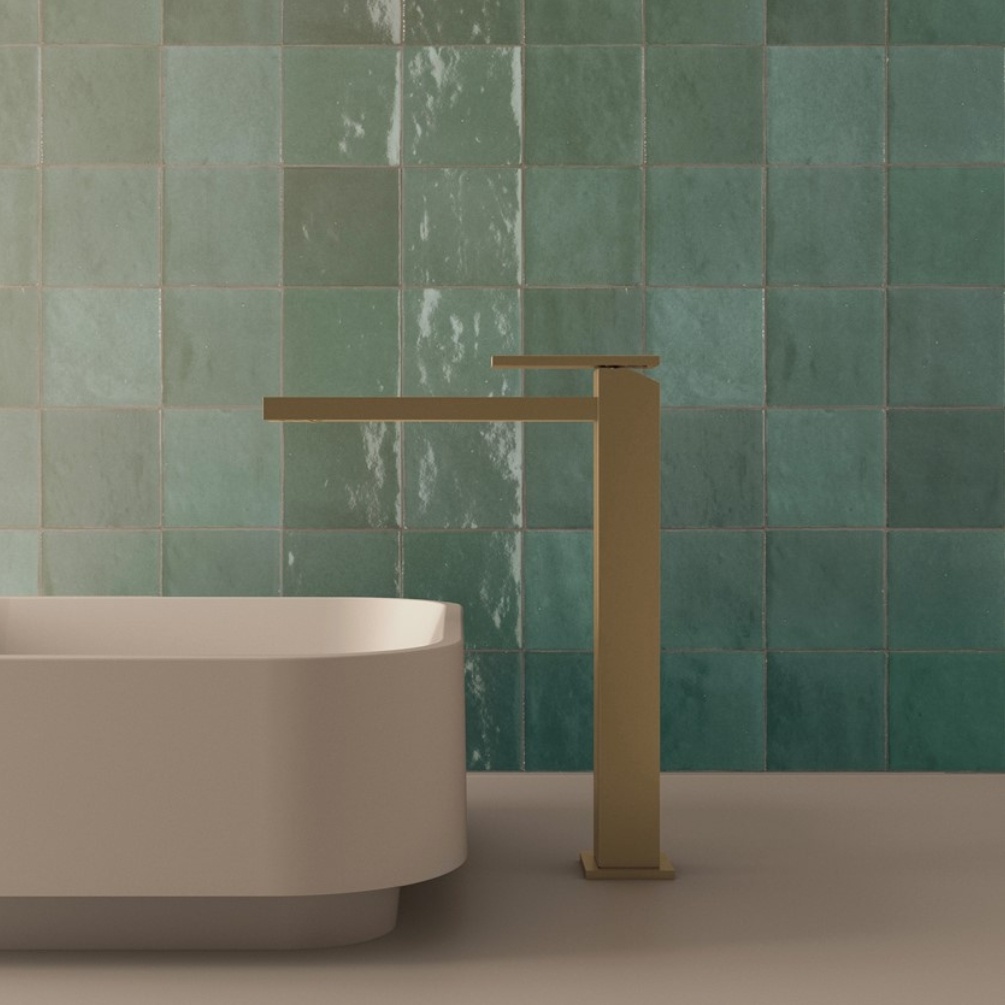 Lifestyle image of the Crosswater Myron Brushed Brass Tall Basin Mixer installed next to a white countertop basin